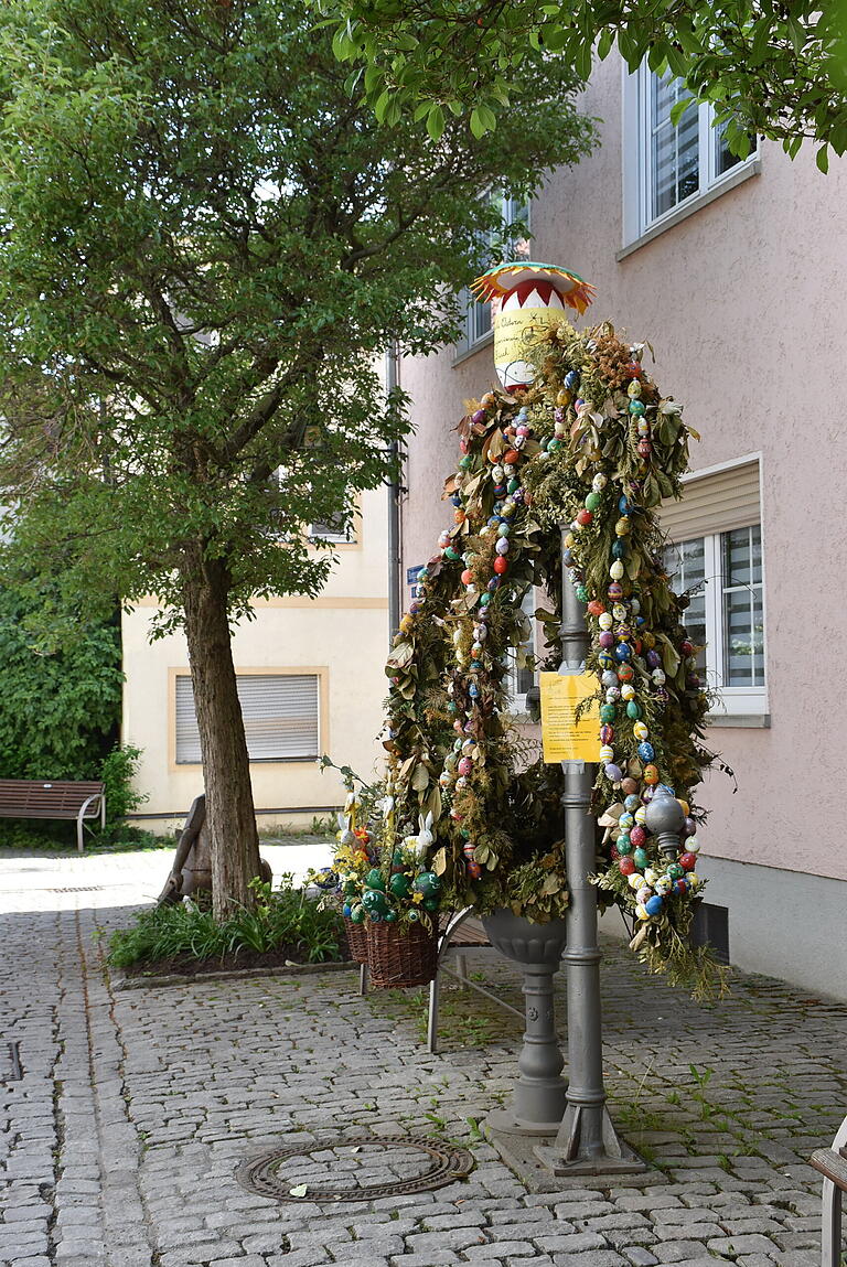 Das Blattwerk ist welk, eigentlich müsste der Osterbrunnen im Stadtviertel Zürch weg. Doch weil ganz oben, gleich unter dem großen Osterei, eine Amselfamilie ihre Brut aufzieht, bleibt er noch etwa vier Wochen stehen.