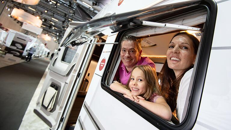 Fotomodels schauen auf der Reisemesse CMT aus einem Wohnmobil. Auch bei Familien und jungen Leuten wird Urlauben im Campingmobil&nbsp; immer beliebter.