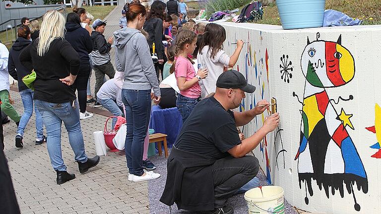 Schüler und Eltern rückten gleichermaßen den grauen Mauern an der Ebelsbacher Schule mit Farbe auf den Leib.