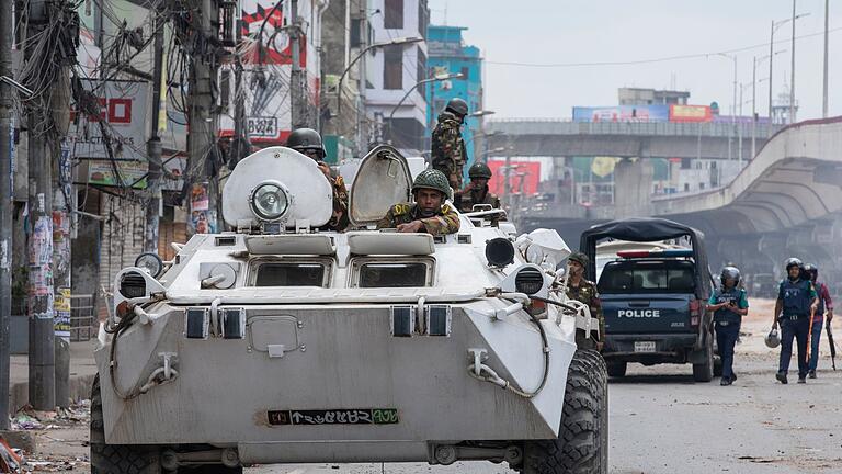 Studentenproteste in Bangladesch       -  Bangladeschische Militärkräfte patrouillieren auf gepanzerten Fahrzeugen in den Straßen von Dhaka