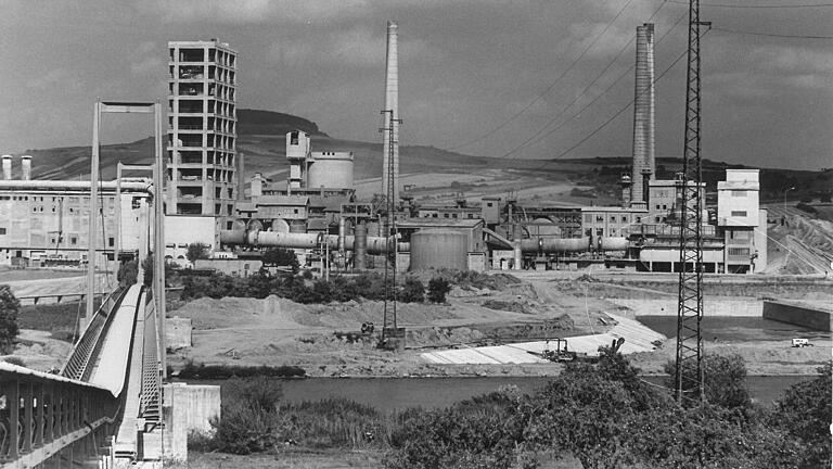 Das Zementwerk Schwenk 1967, vom Steinbruch aus gesehen. Links läuft das Förderband über den Main. Der Hafen rechts steht kurz vor der Vollendung. Das Zementwerk Schwenk 1967, vom Steinbruch aus gesehen. Links läuft das Förderband über den Main. Der Hafen rechts steht kurz vor der Vollendung.