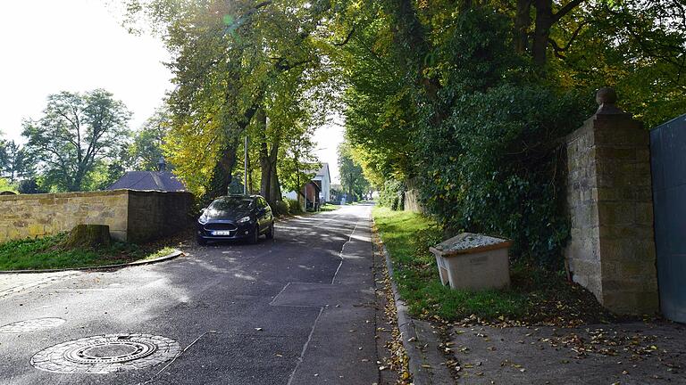 Die Obbacher Ortsstraße Am Heimbach entlang des Friedhofs (links) und des Schlossparks (rechts) soll erneuert und mit einem Gehweg ergänzt werden. Über den Umgang mit den Bäumen gab es unterschiedliche Ansichten in der Bürgerversammlung.