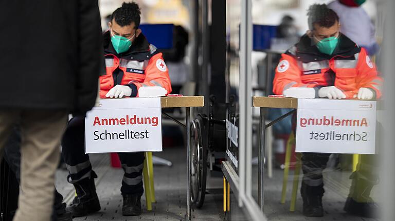 Einige Menschen stehen in einer Schlange, um sich für einen Schnelltest in der Tübinger Innenstadt anzumelden.