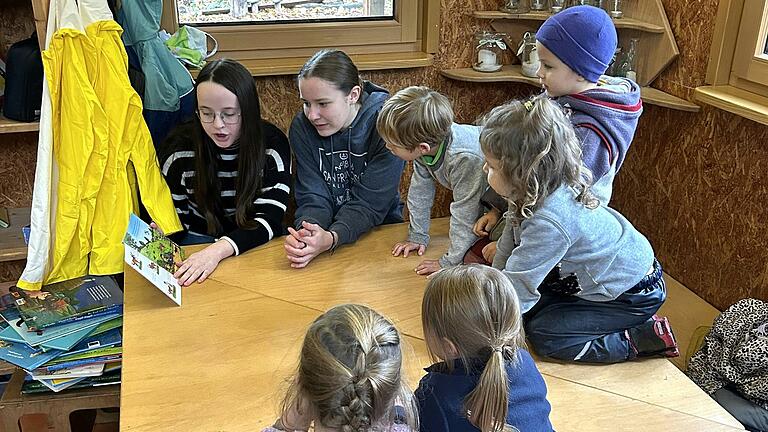 Neuntklässlerinnen der Realschule beim Vorlesen im Waldkindergarten.