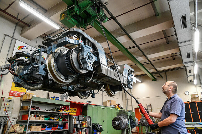Der Deckenkran transportiert ein Fahrwerk durch die Halle zum Montagestand. Der Deckenkran transportiert ein Fahrwerk durch die Halle zum Montagestand. 