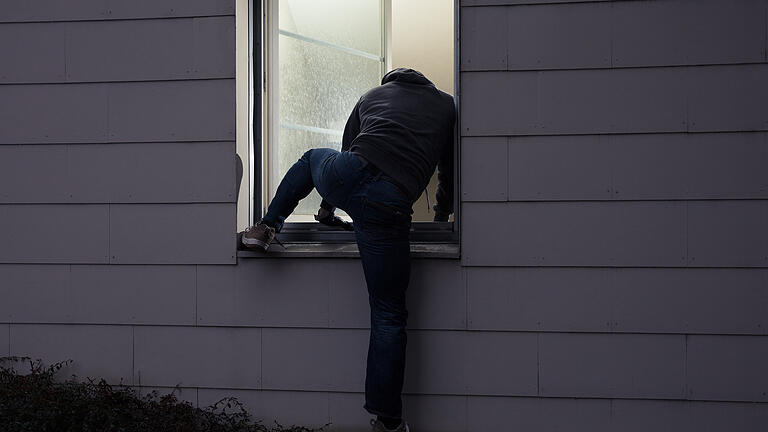 Burglar Entering House Through Window       -  Symbolbild: Einbrecher