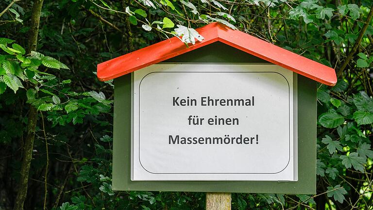 'Kein Ehrenmal für einen Massenmörder': Dieses Schild steht auf einem Waldstück, das Anhängern der umstrittenen Glaubensgemeinschaft 'Universelles Leben' gehört. 'Kein Ehrenmal für einen Massenmörder': Dieses Schild steht auf einem Waldstück, das Anhängern der umstrittenen Glaubensgemeinschaft 'Universelles Leben' gehört. 
