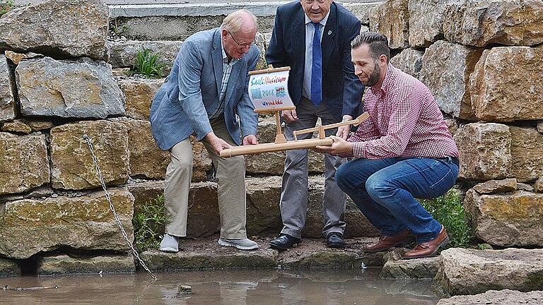 Am Weisbach in der Dorfmitte von Ipthausen ließen Professor Ernst Oestreicher, zweiter Bürgermeister Philipp Sebald und Erdinc Yurdakul von der Projektleitung des SaaleMusicum das Floß zu Wasser. Der Weisbach ist ein Zufluss der Fränkischen Saale.