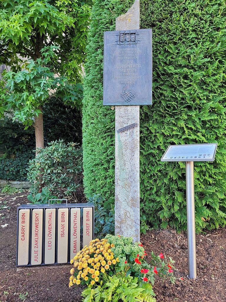 Seit 2007 steht auf dem Edeka-Parkplatz eine Stele, mit der an das Schicksal der Estenfelder Juden erinnert wird. Nun wurde der Gedenkort um ein Gepäckstück und eine Informationstafel ergänzt.