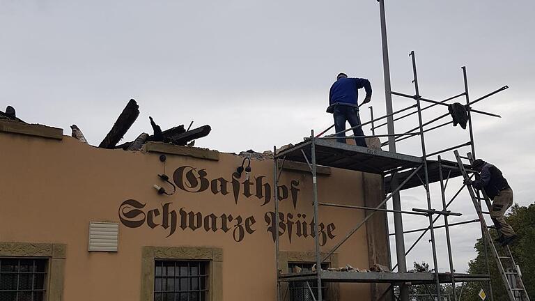 Mit Vorschlaghammer und Bagger wurde am Freitag das Dach des ehemaligen Gasthofes Schwarze Pfütze eingerissen. Foto: Susanne Will       -  Mit Vorschlaghammer und Bagger wurde am Freitag das Dach des ehemaligen Gasthofes Schwarze Pfütze eingerissen. Foto: Susanne Will