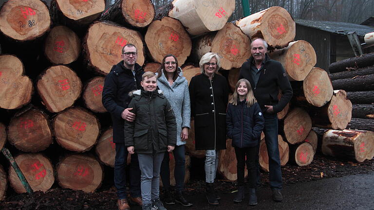 Generationswechsel im Sägewerk Bauerschmitt, vor besonderen Stämmen von Wertholz, mit den jungen Nachfolgern Michael und Katja Bauerschmitt sowie den Vorgängern Claudia und Hans Bauerschmitt (hintere Reihe, von links). Die vierte Generation mit Jonas (vorne links) und Lina ist auch schon dabei.