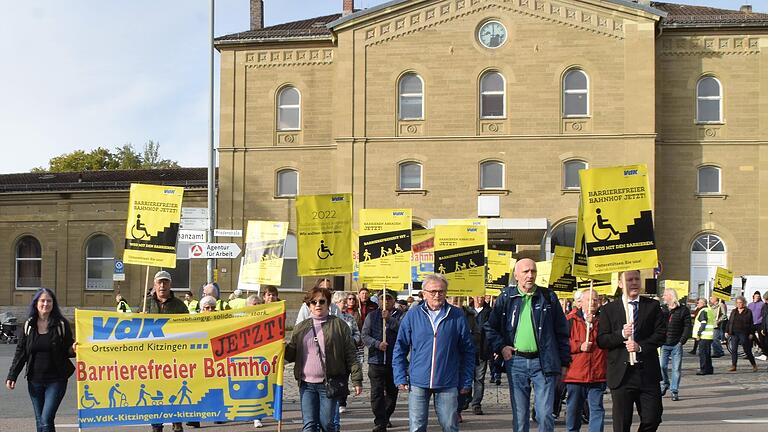 Vor einem Jahr forderten Teilnehmerinnen und Teilnehmer einer VdK-Demonstration in Kitzingen: 'Barrierefreier Bahnhof – jetzt'. Beschleunigt hat die Aktion nichts.