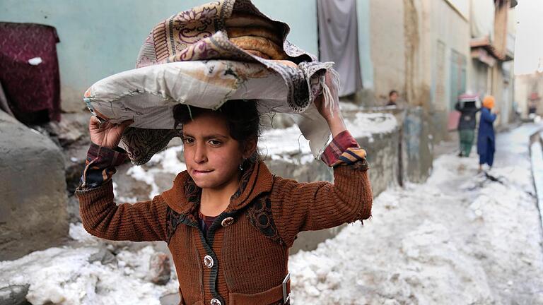 Winter in Afghanistan: Ein Mädchen trägt Brote auf dem Kopf, während es durch den Schnee geht. Das Bild entstand am 8. Februar dieses Jahres in Kabul, der Hauptstadt Afghanistans. Foto: Hussein Malla/AP/dpa       -  Winter in Afghanistan: Ein Mädchen trägt Brote auf dem Kopf, während es durch den Schnee geht. Das Bild entstand am 8. Februar dieses Jahres in Kabul, der Hauptstadt Afghanistans. Foto: Hussein Malla/AP/dpa