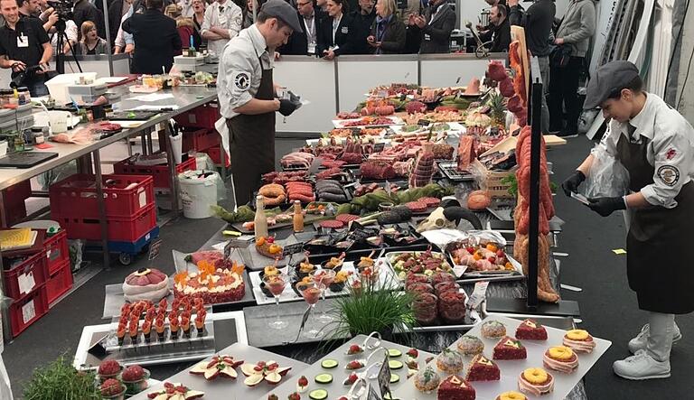 Fertig für die Begutachtung der Jury: Auf einem Präsentationstisch (im Bild der Tisch von der WM 2018 in Belfast) muss das Team nach Ablauf der Zeit alle fertigen Fleischstücke ansprechend präsentieren. Fertig für die Begutachtung der Jury: Auf einem Präsentationstisch (im Bild der Tisch von der WM 2018 in Belfast) muss das Team nach Ablauf der Zeit alle fertigen Fleischstücke ansprechend präsentieren. 