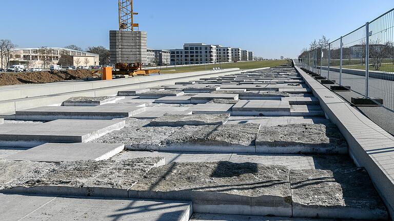 Für die Sanierungsarbeiten am Wasserbecken müssen Hunderte von Natursteinen unterschiedlicher Größe einzeln per Kran ausgebaut und auf der benachbarten Fläche gelagert werden.