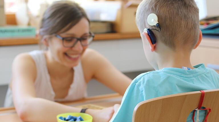 Während der 1:1-Betreuung berühren sich die Pädagogin und der Schüler an den Händen, um zu kommunizieren. Während der 1:1-Betreuung berühren sich die Pädagogin und der Schüler an den Händen, um zu kommunizieren.