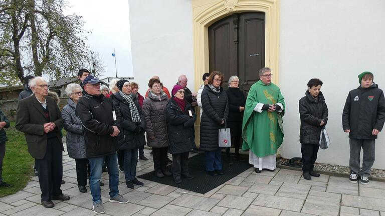 Versammelt im Gedenken an die Opfer von Krieg und Gewalt am Kriegerdenkmal vor der Gernacher Kirche St. Aegidius. Aufmerksam hören sie die Worte von Gemeinderat Dieter Dietz, der an die Opfer von Krieg und Gewalt erinnert, aber auch dazu auffordert, sich für den Frieden und für Verständigung einzusetzen.