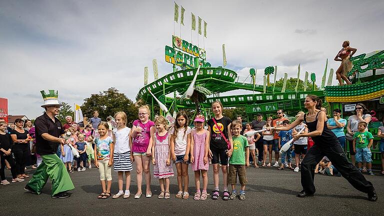 Spiel, Spaß und Action beim traditionellen Kinderfestumzug auf dem Volksfest       -  (oli)   Zahlreiche Kinder und ihre Eltern oder Großeltern kamen Freitagnachmittag zum Volksfest, natürlich wegen der Fahrgeschäfte und der Zuckerwatte, aber auch wegen des Kinderfestumzugs, bei dem die Tanzmariechen, die Jonglierschule Firlefanz und die Schweinfurter Stadtpfeiffer durchs Volksfest zogen. An vier Stationen zeigten sie Showeinlagen &ndash; Jonglieren auf Stelzen, Jonglieren über mutige Freiwillige (im Bild mit Mathias und Silke Ebert), Trapezkunst oder Turneinlagen. Dazu gab es Luftballonsteigenlassen mit 20 Preisen für die weitesten Flüge sowie einen Kindermalwettbewerb. Das Volksfest endet Montagabend mit dem traditionellen Feuerwerk ab 22.30 Uhr. Am Sonntag findet um 10.30 Uhr im Festzelt der ökumenische Volksfestgottesdienst mit Pfarrer Heiko Kuschel und Pastoralreferent Ulrich Göbel statt. Viele Bilder vom Fest und vom Umzug unter www.mainpost.de/schweinfurt. Ein Video gibt es unter www.facedbook.com/schweinfurter.tagblatt