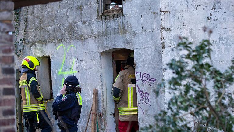 Tunnel unter Lützerath       -  Einsatzkräfte stehen vor dem Gebäude, unter dem sich zwei verbliebene Aktivisten in einem Tunnel verschanzt haben.