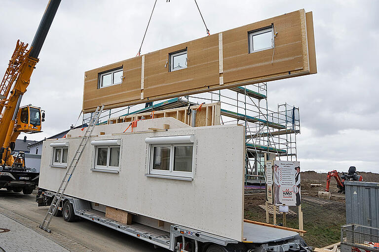 Beim Holzhaus bringt der Kran die vorgefertigten Module an der Baustelle in die richtige Position.