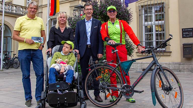 Die beiden 'Hand-in-Hand'-Vereinsvorsitzenden Folker Quack und Birgit Hardt mit ihrem Sohn Dario verabschieden mit Würzburgs Oberbürgermeister Christian Schuchardt den Würzburger Radler Jörg Richter (von links) vor seiner geplanten Spendentour durch Österreich.