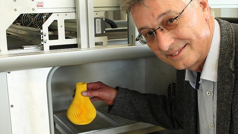 SKZ-Bereichsleiter Georg Schwalme holt aus der &bdquo;Brennkammer&rdquo; eines 3D-Druckers einen Gegenstand aus Kunststoff. Das Institut forscht zusammen mit der Industrie und Hochschulen.Fotos: Jürgen Haug-Peichl