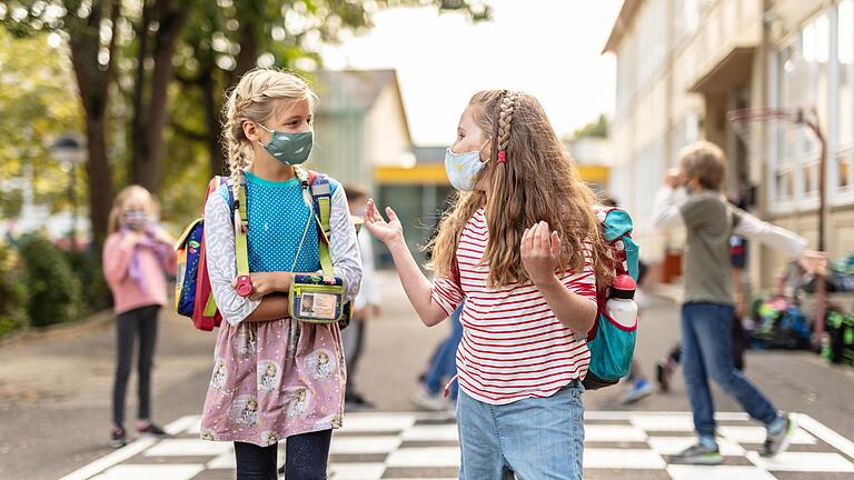 Zwei Schülerinnen einer Würzburger Grundschule unterhalten sich auf diesem Symbolbild auf dem Pausenhof. Ab 2025 gibt es einen Rechtsanspruch für Eltern auf Ganztagesbetreuung auch in der Grundschule.