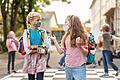 Zwei Schülerinnen einer Würzburger Grundschule unterhalten sich auf diesem Symbolbild auf dem Pausenhof. Ab 2025 gibt es einen Rechtsanspruch für Eltern auf Ganztagesbetreuung auch in der Grundschule.