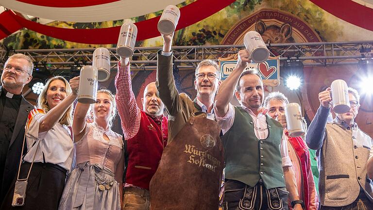 Würzburgs Oberbürgermeister Christian Schuchardt (Mitte) hält einen Bierkrug nach dem Fassanstich beim offiziellen Start des Kiliani-Volksfestes. Würzburgs Oberbürgermeister Christian Schuchardt (Mitte) hält einen Bierkrug nach dem Fassanstich beim offiziellen Start des Kiliani-Volksfestes.