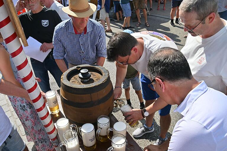 Unter den Augen der Mitglieder des Festausschusses und seines italienischen Kollegen Erigo Pecci (rechts) schenkte Bürgermeister Alexander Knahn (Mitte) das erste Fass zum offiziellen Start des Marktfestes aus.