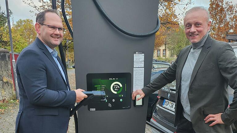 Michael Hombach, Bürgermeister der Stadt Karlstadt, (links) und Marek Zelezny, Geschäftsführer von 'Die Energie' nehmen die Ladesäule in Betrieb.