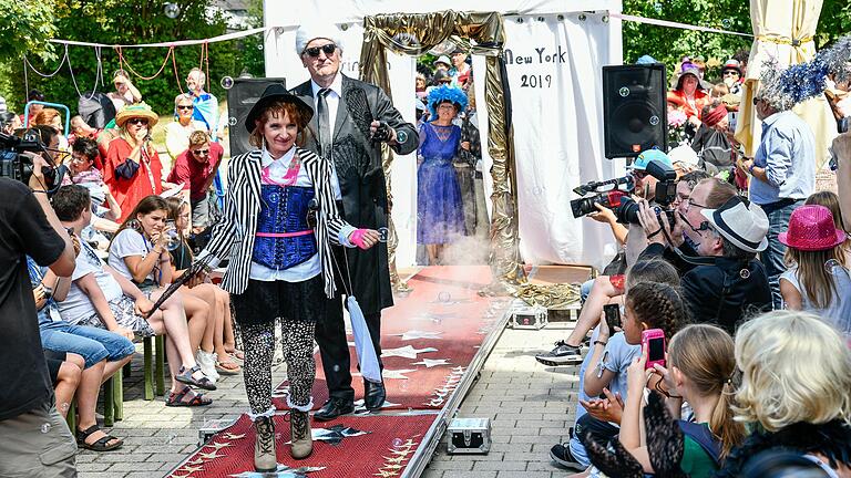 Bürgermeisterin Ursula Engert, als Modedesignerin Vivienne Westwood, und der Leiter des St. Josef-Stifts, Bernhard Götz, im Gewand des Modeschöpfers Karl Lagerfeld, eröffneten die Modeschau in Eisingen.