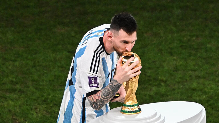 WM 2022 - Argentinien - Frankreich - 18.12.2022, Katar, Lusail: Fußball, WM, Argentinien - Frankreich, Finalrunde, Finale, Lusail Stadion, Argentiniens Lionel Messi küsst den WM-Pokal. Foto: Robert Michael/dpa +++ dpa-Bildfunk +++ WM 2022 - Argentinien - Frankreich - 18.12.2022, Katar, Lusail: Fußball, WM, Argentinien - Frankreich, Finalrunde, Finale, Lusail Stadion, Argentiniens Lionel Messi küsst den WM-Pokal. Foto: Robert Michael/dpa +++ dpa-Bildfunk +++