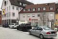 Das bestehende Gebäude mit der Adresse Rathausplatz 1 befindet sich im Eigentum der Sparkasse Mainfranken. Es soll abgerissen und durch einen modernen Neubau mit vier Geschossen ersetzt werden.