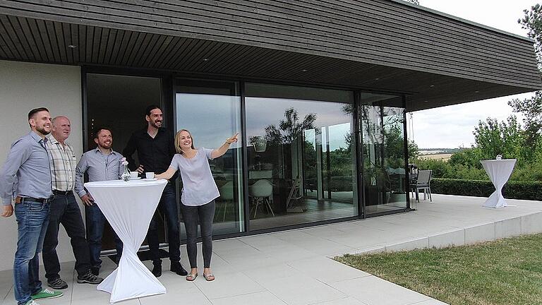 Genossen von der Terrasse ihres Anwesens aus den herrlichen Blick auf die Rhön: Andreas Dörr (links), Isabell Dörr (rechts) und Architekt Dominik Wukowojac (Zweiter von rechts) mit Besuchern der &bdquo;Architektouren&ldquo;.