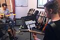 Gitarrenlehrer Gerald Brand (links) setzt im Unterricht die Akkord-Spielkarten ein, die seinem Schüler vorgeben, was er spielen soll.
