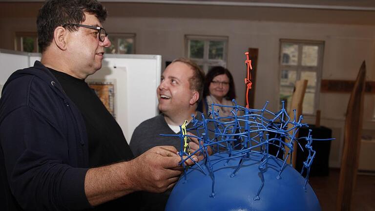 Künstler Clemens Kaspar Hegler erklärt eine seiner Installationen bei der Eröffnung des Kunstkaufhauses des KulturPackts im Alten Gymnasium in Schweinfurt, das dort bis 28. Mai geöffnet hat. Künstler Clemens Kaspar Hegler erklärt eine seiner Installationen bei der Eröffnung des Kunstkaufhauses des KulturPackts im Alten Gymnasium in Schweinfurt, das dort bis 28. Mai geöffnet hat.