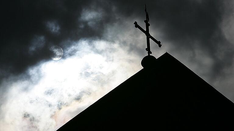 Kreuz im Gegenlicht       -  Dunkle Wolken über der katholischen Kirche: Jetzt wurde bekannt, dass es erneut Vorwürfe des sexuellen Missbrauchs gegen einen Ruhestandspriester in der Diözese Würzburg gab.