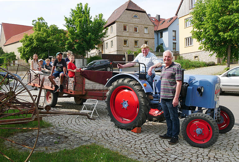 Auch das gehörte zum Museumstag in Mühlhausen. Albin Glück und Vorstand Otto Füller (von rechts) vom Verein zur bäuerlichen und handwerklichen Kulturerhaltung (VKM) fuhren Kinder mit dem vereinseigenen Oldtimer-Schlepper (Baujahr 1956) durch das Dorf und die Flur.