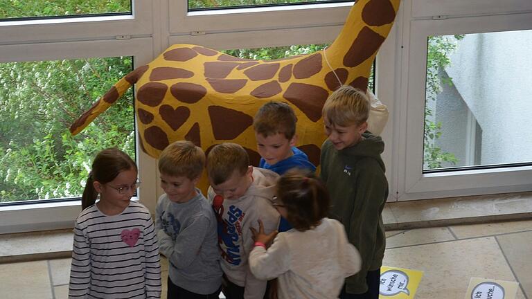 Kinder der ersten Klasse zeigen ihren Mitschülern, wie sie mit der Giraffe Gustav Konflikte lösen können.