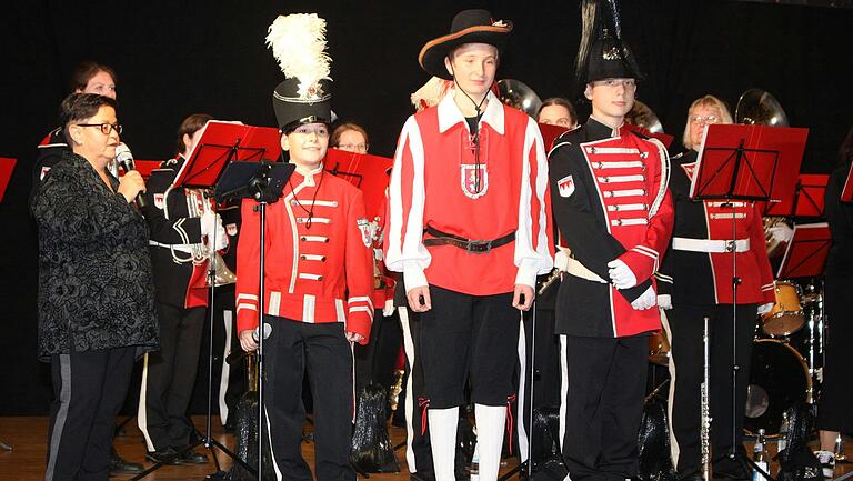 Rot war schon immer eine wichtige Farbe in den Uniformen des modernen Spielmann- und Fanfarenzug Retzbach. In der Mitte die erste Uniform mit Kniebundhose, wie sie vor 40 Jahren viele Musikgruppen trugen, links daneben die erste eigene Uniform von 1995 und rechts die aktuelle aus dem Jahr 2007.