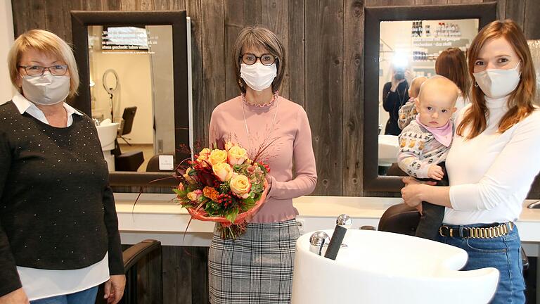 Mit Worten der Wertschätzung, mit Blumen einem Geschenk dankten Friseursaloninhaberin Lisa-Marie Manger mit Töchterchen Emma auf dem Arm (rechts) und Seniorchefin Gerti Manger (links) der langjährigen Mitarbeiterin Petra Joa zum 40. Betriebsjubiläum.