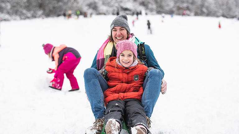 Einige Menschen verbringen den Sonntag 24.01.21 draussen im Freien und genießen den Schnee bei der Rodelbahn im Guttenberger Forst.