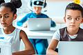 Unsere Autorin ließ die Künstliche Intelligenz 'DALL-E' das Bild generieren. Ihr Vorschlag an die KI: Schülerinnen und Schüler, die im Klassenzimmer künstliche Intelligenzen verwenden.