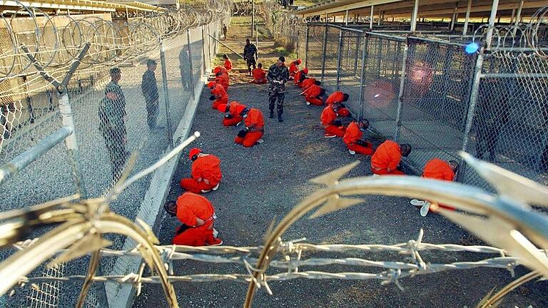 US-Richter: Guantanamo-Häftlinge dürfen Gefangenschaft anfechten - Umstrittene Haftanstalt: In orangefarbene Overalls gekleidet sitzen Häftlinge im US-Straflager Guantánamo auf Kuba. US-Richter: Guantanamo-Häftlinge dürfen Gefangenschaft anfechten - Umstrittene Haftanstalt: In orangefarbene Overalls gekleidet sitzen Häftlinge im US-Straflager Guantánamo auf Kuba.