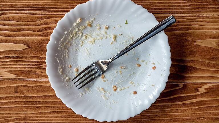 Empty plate of food after meal on a wooden table - _ Empty plate of food after meal on a wooden table - _