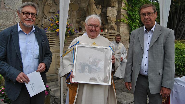 Ein Bild von der Pfarrkirche Brendlorenzen bekam Pfarrer Hans Beetz anlässlich seines 70. Geburtstages von der Pfarrgemeinde St. Johannes der Täufer geschenkt. Von links: Günter Henneberger, der Sprecher des Pfarrgemeinderates, Pfarrer Hans Beetz und Kirchenpfleger Edgar Zeiß.