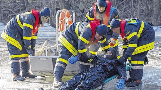 Eisrettungsübung: Bei minus 14 Grad Luft- und vier Grad Wassertemperatur spielt Hilmar Schömig einen ins Eis Eingebrochenen. Seine Kollegen von der Berufsfeuerwehr Würzburg &bdquo;retten&ldquo; ihn hier mit einer Trage.