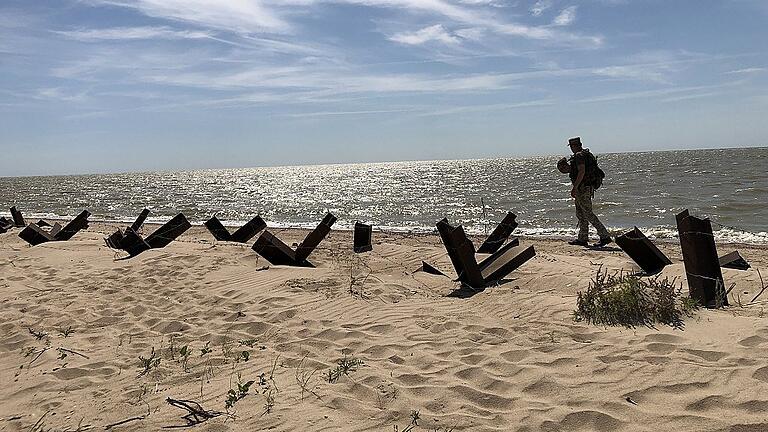Wo die Ukraine an das Asowsche Meer grenzt: Ein Soldat sucht am Strand nach Blindgängern. Wo die Ukraine an das Asowsche Meer grenzt: Ein Soldat sucht am Strand nach Blindgängern.