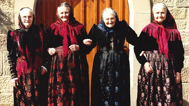 1993 haben sich die letzten vier Galderschummer Frääli für ein Gruppenfoto angezogen. Von links: Ositha Müller, Hilde Treutlein, Margarete Wolz und Maria Treutlein. Müller und Wolz haben für das Foto ausnahmsweise noch einmal ihren Hochzeitskörres angezogen, während Hilde und Maria Treutlein im Blusenkleid (wie damals für Feiertage üblich) gekleidet sind. Die rote Farbe der Schürzen und Tücher steht für einen Feiertag und blau steht für Abtrauer.